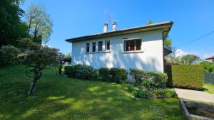 托农莱班Villa La Moraine的一座白色的小房子,有绿色的院子