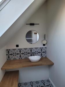 瓦图In de Voorstad Watou的浴室的镜子柜台上有一个碗