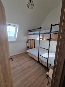 瓦图In de Voorstad Watou的客房设有两张双层床,铺有木地板。