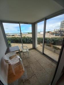 波尔尼谢Appartement T3 - 4 personnes - Face Océan - Thalasso的阳台配有桌子和长凳,享有海滩美景。