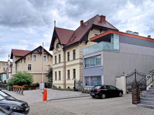 莱什诺Paderewskiego 9 Aparth的前面有一辆汽车停放的大房子