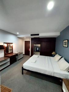 清迈旅行者客栈酒店的卧室配有一张白色大床和一张书桌