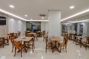 乌穆阿拉马Hotel Caiuá Express Umuarama的用餐室配有木桌和椅子