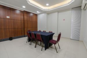 乌穆阿拉马Hotel Caiuá Express Umuarama的一间会议室,配有黑桌子和红色椅子