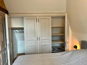 德文格洛Schaapskooi 20的卧室配有白色橱柜和一张床