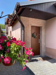 KrzywopłotyAgroturystyka ‚U Misia’的门前有粉红色花朵的房子