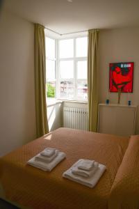 佩萨罗Casa Mameli - Pesaro Centro/Mare的一间卧室配有一张床,上面有两条毛巾