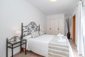休达德亚格山度假屋的白色的卧室配有白色的床和玻璃桌
