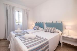 休达德亚格山度假屋的卧室设有2张床,配有白色和蓝色