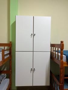 里约热内卢Rio Hostel 40 Graus的配有两张双层床的客房内的2个白色橱柜