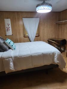 南金斯敦Legend Rock Lodge的卧室配有白色的床、窗户和钢琴