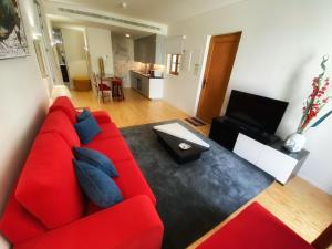里斯本TM Luxury Apartments Lisbon的客厅里的红色沙发