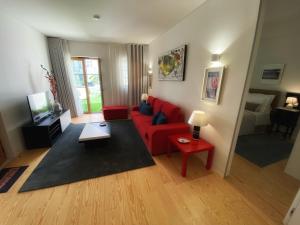 里斯本TM Luxury Apartments Lisbon的客厅配有红色沙发和红色桌子