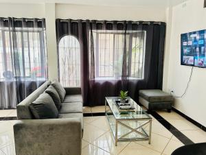 瓜亚基尔Comfortable 3-Bedroom Condo in Bellavista, Guayaquil的带沙发和玻璃桌的客厅
