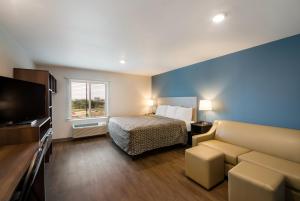奥斯汀WoodSpring Suites Austin Central的酒店客房,配有床和沙发