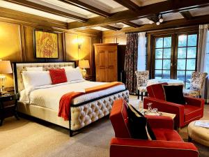 悉尼The Latch Inn的一间卧室配有一张大床和一张红色椅子