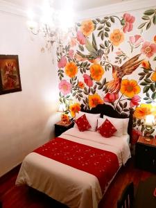 库斯科Casona Dorada Hotel Cusco的一间卧室配有一张带花卉墙壁的床