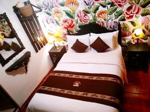 库斯科Casona Dorada Hotel Cusco的一间卧室配有一张带花卉墙壁的床