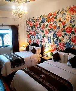 库斯科Casona Dorada Hotel Cusco的一张位于酒店客房的床铺,配有花卉壁纸
