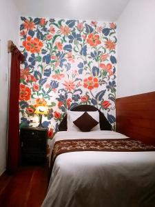 库斯科Casona Dorada Hotel Cusco的一间卧室配有花卉图案的壁纸和一张床