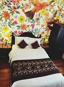 库斯科Casona Dorada Hotel Cusco的一间卧室配有一张带花卉壁纸的床