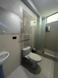 普卡尔帕Adrian´s Hotel的白色的浴室设有卫生间和水槽。