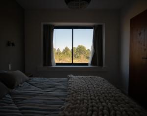 拉库布蕾Casa en la naturaleza con vistas a las Sierras的一间卧室设有一张大床和一个窗户。
