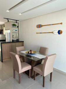 卡马萨里Casa Completa com piscina, 800m da praia de Jauá的一间带桌椅的用餐室和一间厨房