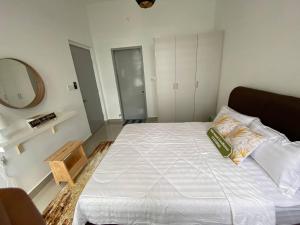 加影Fatih Amani Guesthouse with Playstation PS3的卧室配有一张带镜子的白色大床