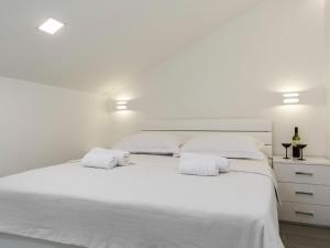 伊莫茨基Pretty Apartment in Imotski close to River的白色卧室配有一张大白色床和两个白色枕头