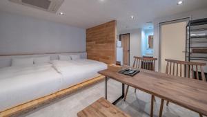 高山Relax Hotel Takayama Station的一间卧室配有一张床和一张木桌