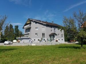 AltenrheinSchönes Studio direkt am Bodensee的一座带绿色草坪的大型白色房屋