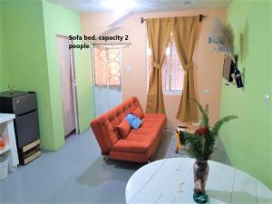 ChimaltenangoCOMFY furnished private apartment.Netflix/internet的客厅配有橙色沙发和桌子