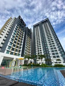 大山脚RUMA Executive Homestay Bukit Mertajam with Pool Netflix #FREETAX的两座高楼,前面有一个游泳池