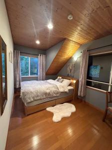 山中湖村4月リニューアルOpen! 全室エアコン完備! Deerview Lodge 山中湖的一间卧室设有一张木天花板床。