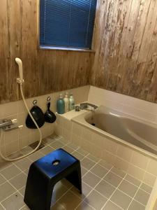 山中湖村4月リニューアルOpen! 全室エアコン完備! Deerview Lodge 山中湖的带浴缸和蓝色凳子的浴室