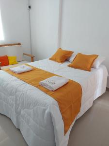 YurimaguasMajestic Mical的一张配有橙色和白色床单及枕头的大床