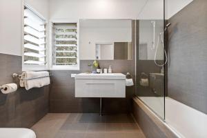 拜伦湾阿曼&辛塔豪华别墅的浴室配有白色水槽和淋浴。