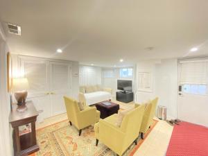 华盛顿Renovated English Basement 2bdrm Home near METRO的客厅配有床、椅子和桌子