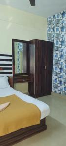 奎隆Hotel Orginal Residency的一间卧室配有一张床、梳妆台和镜子