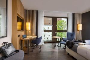 因戈尔施塔特Maritim Hotel Ingolstadt的酒店客房带一张床、一张桌子和椅子