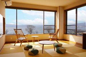 诹访市Suwakoen的一间设有两把椅子和一张桌子的房间,窗户