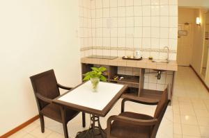 哥打京那巴鲁海滨服务式公寓的厨房配有桌椅和水槽。