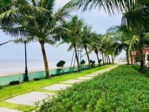 清化Villa 216 Eureka Linh Trường - Hải Tiến的一条棕榈树环绕的海滩小径