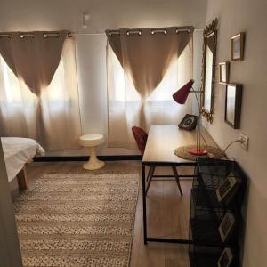 特拉维夫Jaffa Seaside House的客房设有桌子和带窗帘的窗户。