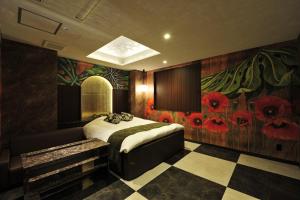 丰中HOTEL the QUEEN的卧室配有一张挂着红色鲜花的床。