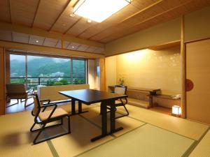 神户有马日式旅馆的一间带桌椅和窗户的用餐室