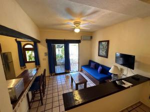 巴亚尔塔港Vallarta Sun Suites的客厅配有蓝色的沙发和桌子