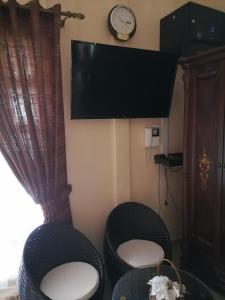 拉戈莱特Villa Soorkea的一间设有两把椅子和一台墙上的电视的房间
