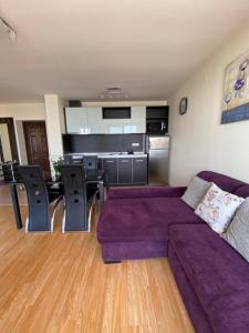 埃勒尼特Sea view apartment in Sveti Vlas的一间带紫色沙发的客厅和一间厨房